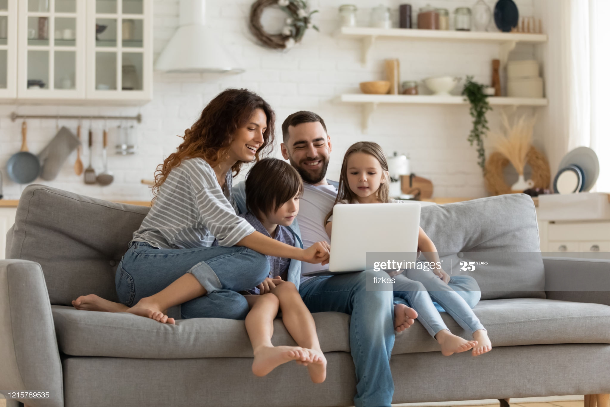 Happy Family Sitting on Sofa Using Laptop – Lebanon, OH – Harold Jarnicki & Associates